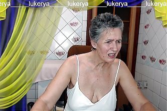 Hot housewife Lukerya with a sweet smile flirts cheerfully on a webcam with fans in the kitchen online.